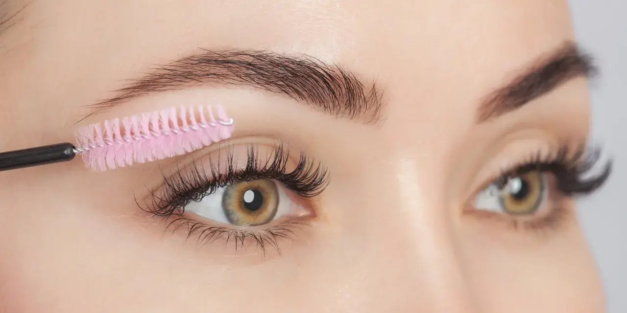 Brosse à cils rose peignant des cils longs et épais. Attention aux dangers de l'huile de ricin pour les cils.