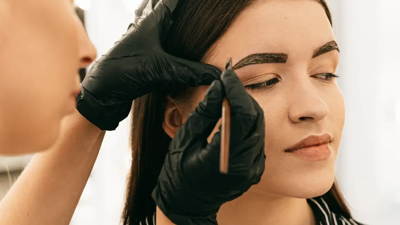 Application de henné sur les sourcils pour un regard intense.