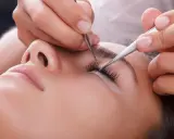Pose de cils pour un rehaussement cil et teinture. Une esthéticienne applique des extensions avec précision.