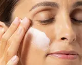 Application d'une crème hydratante contenant de l'acide polyglutamique sur le visage d'une femme.