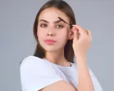Jeune femme se brossant les sourcils. Une préoccupation pour la perte de sourcils avec l'âge, mais ici, ils sont parfaits.
