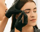 Application de henné sur les sourcils pour un regard intense.