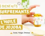 Découvrez les bienfaits surprenants de l'huile de jojoba pour le visage, le corps et les cheveux. Une main tient un flacon d'huile de jojoba.