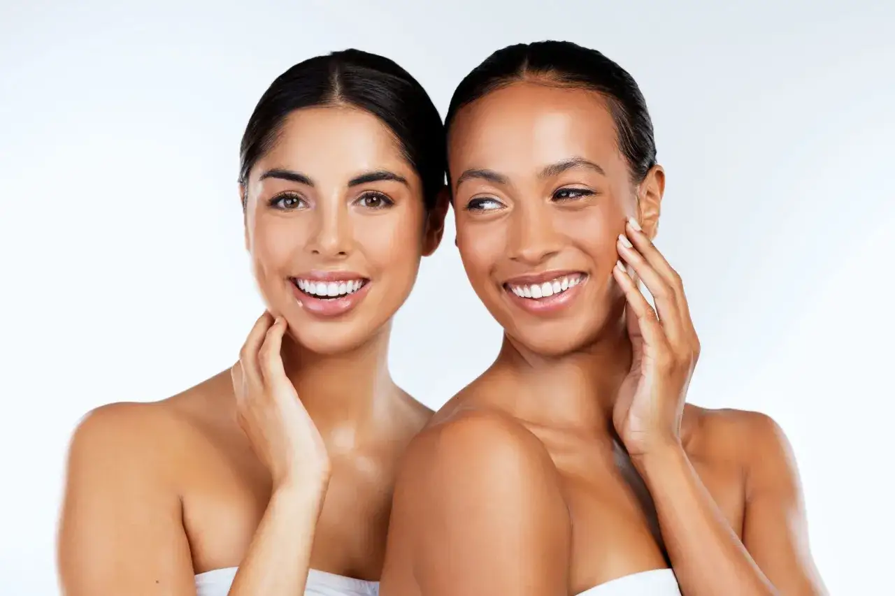 Deux femmes souriantes, peau radieuse après un double nettoyage visage.