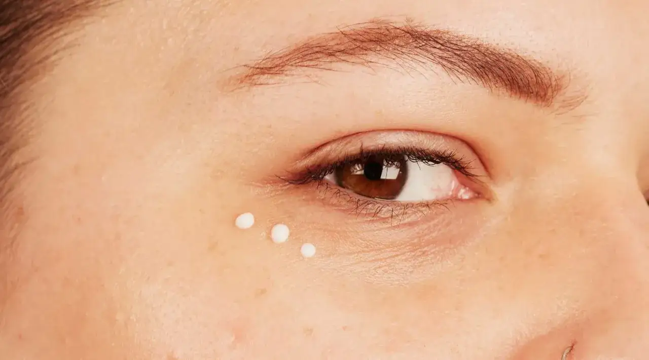 Trois points de crème appliqués sous l'œil pour lutter contre les rides sous les yeux.